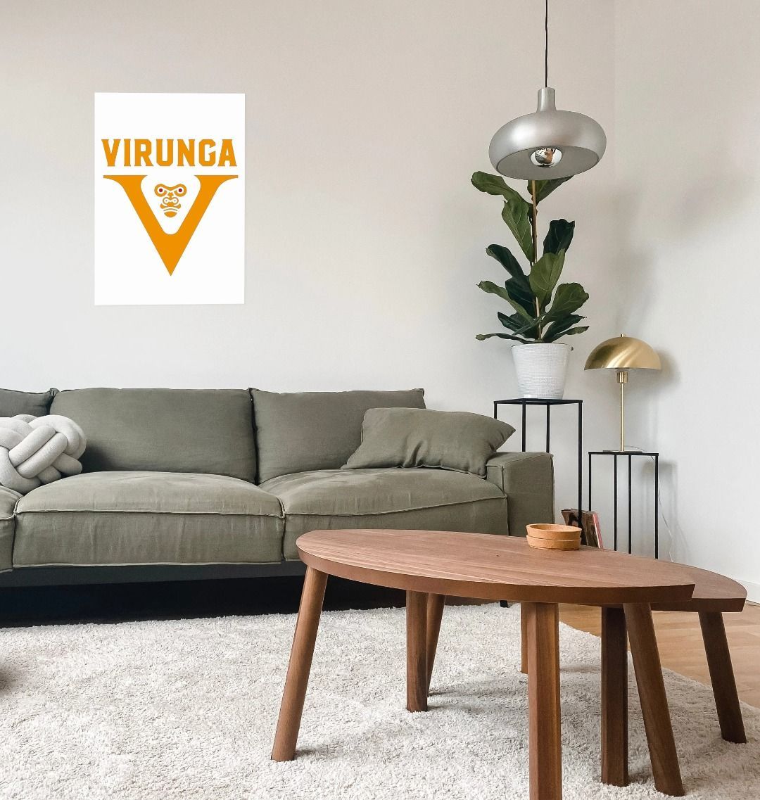 A V for Virunga Poster, displayed on a wall above a modern wooden and upholstered furniture set in a cozy living room setting.