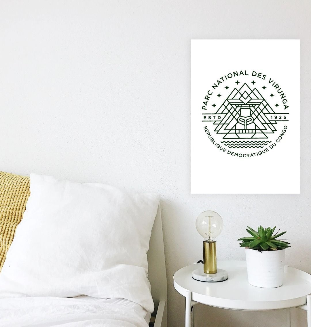 A Virunga Emblem Poster hanging on a wall over a white table in the bedroom.