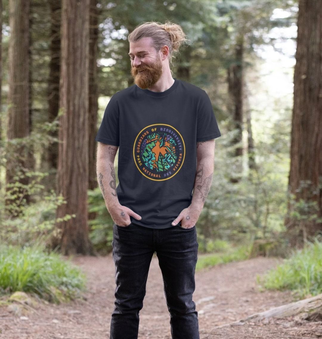 A Man wearing a navy blue Guardians of Biodiversity men's t-shirt in a forest 