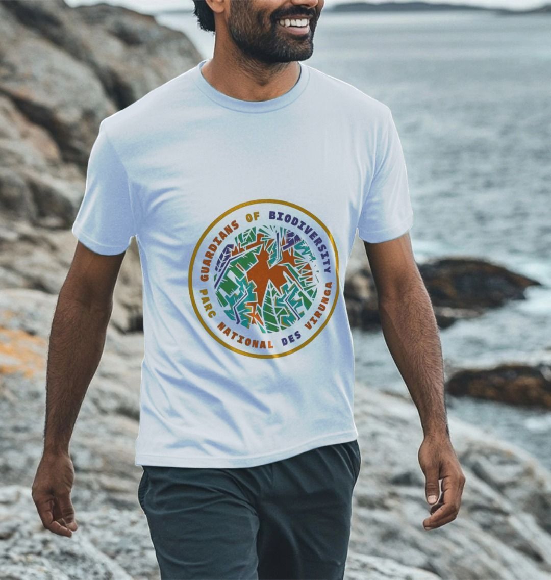 A Man wearing a white Guardians of Biodiversity men's t-shirt by a rocky shoreline