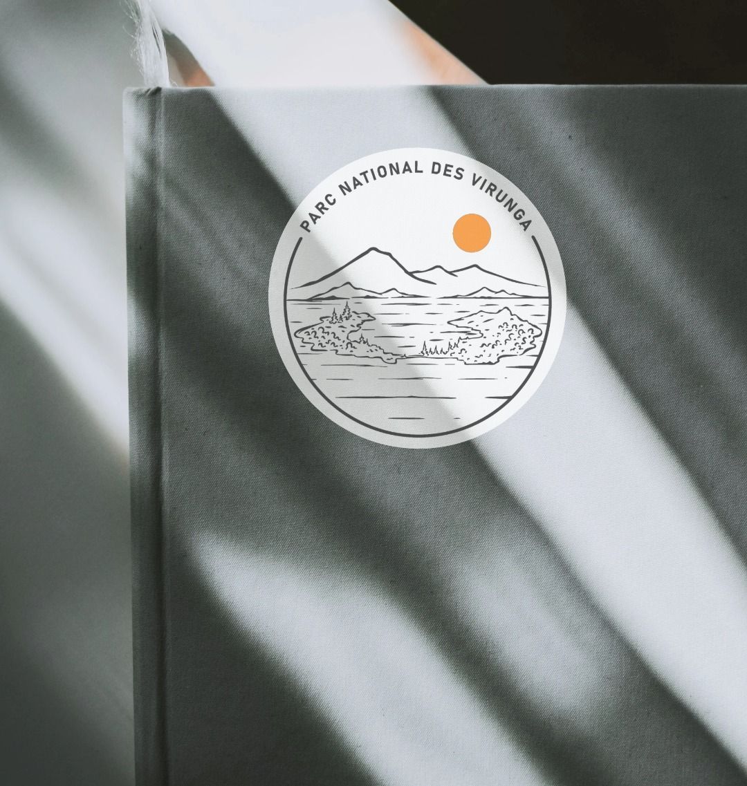 A Tchegera Island Sticker placed on a grey notebook.