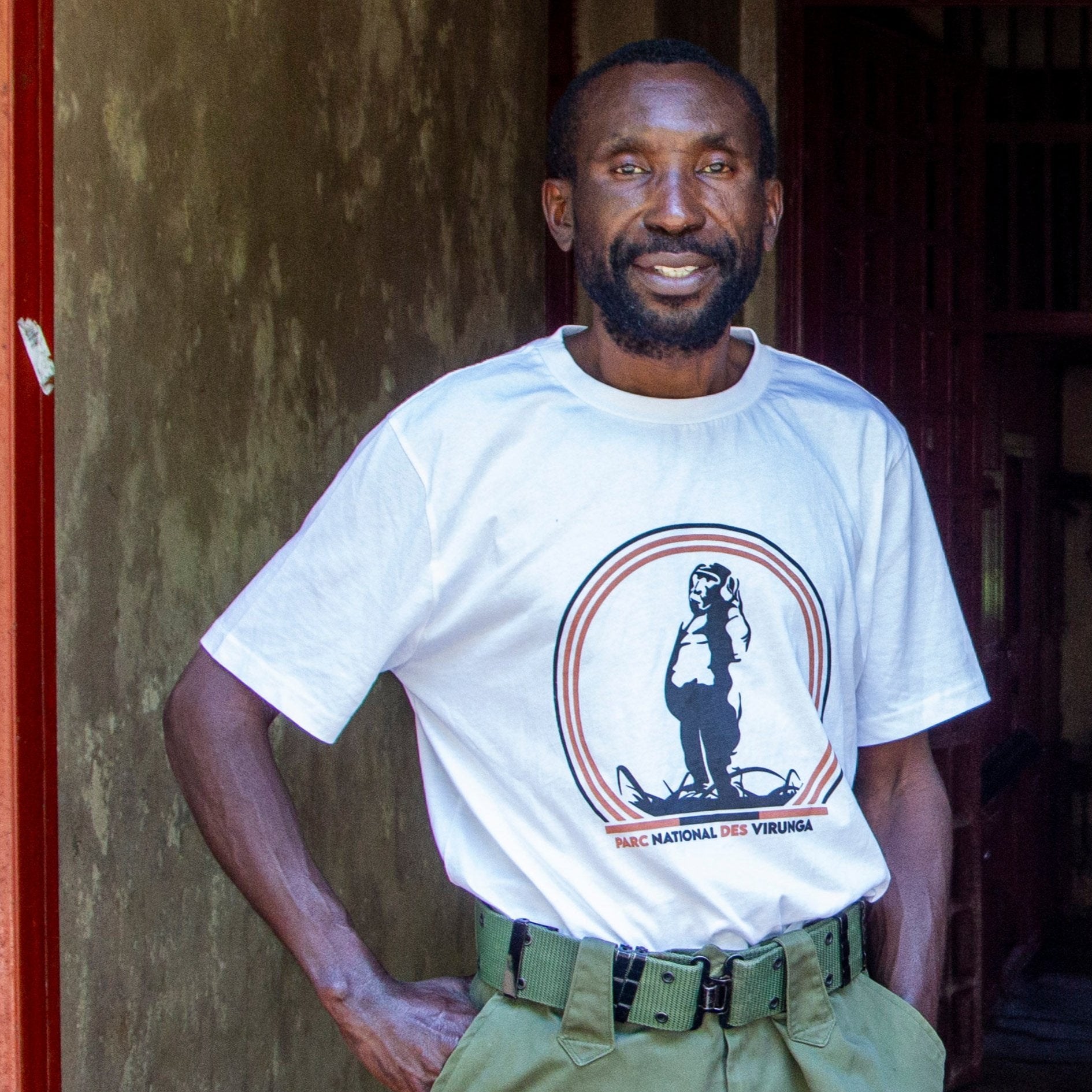 A black man wearing a white Take A Stand Men's T-shirt