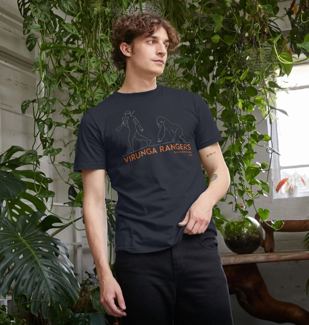 A man standing in a room with plants wearing a navy blue Mountain Gorilla Ranger Men's T-shirt