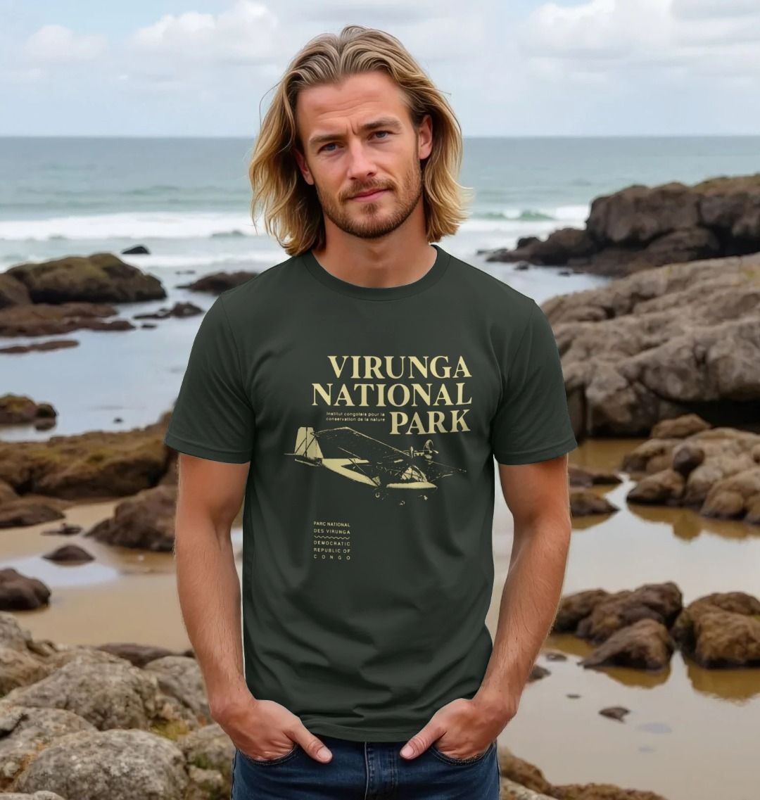 A man wearing a dark grey Virunga Pilot Men's T-shirt on a beach.