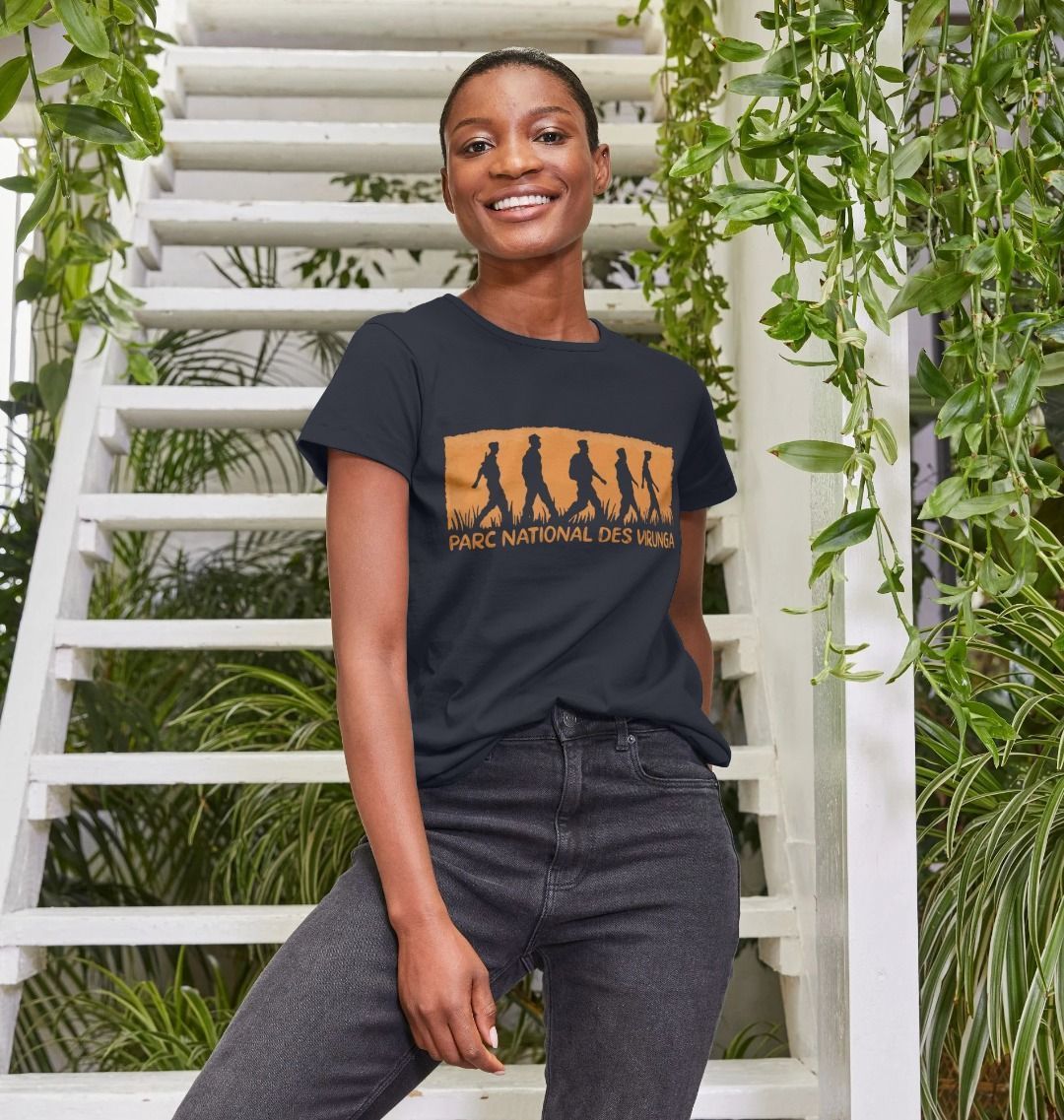 A woman wearing a black Virunga Rangers Women's Top, standing in front of a white staircase with greenery.
