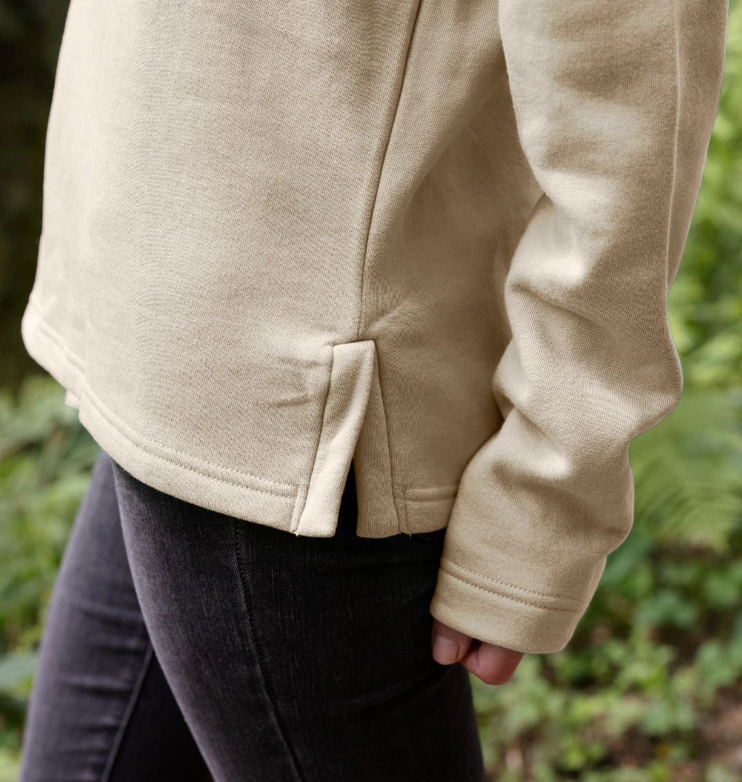 A woman wearing a an oat retro elephant women's hoodie and a black pant