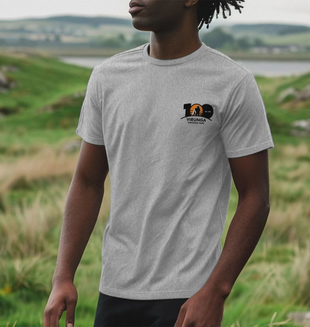A man wearing an athletic gray Virunga 100 Men's T-shirt in a natural setting