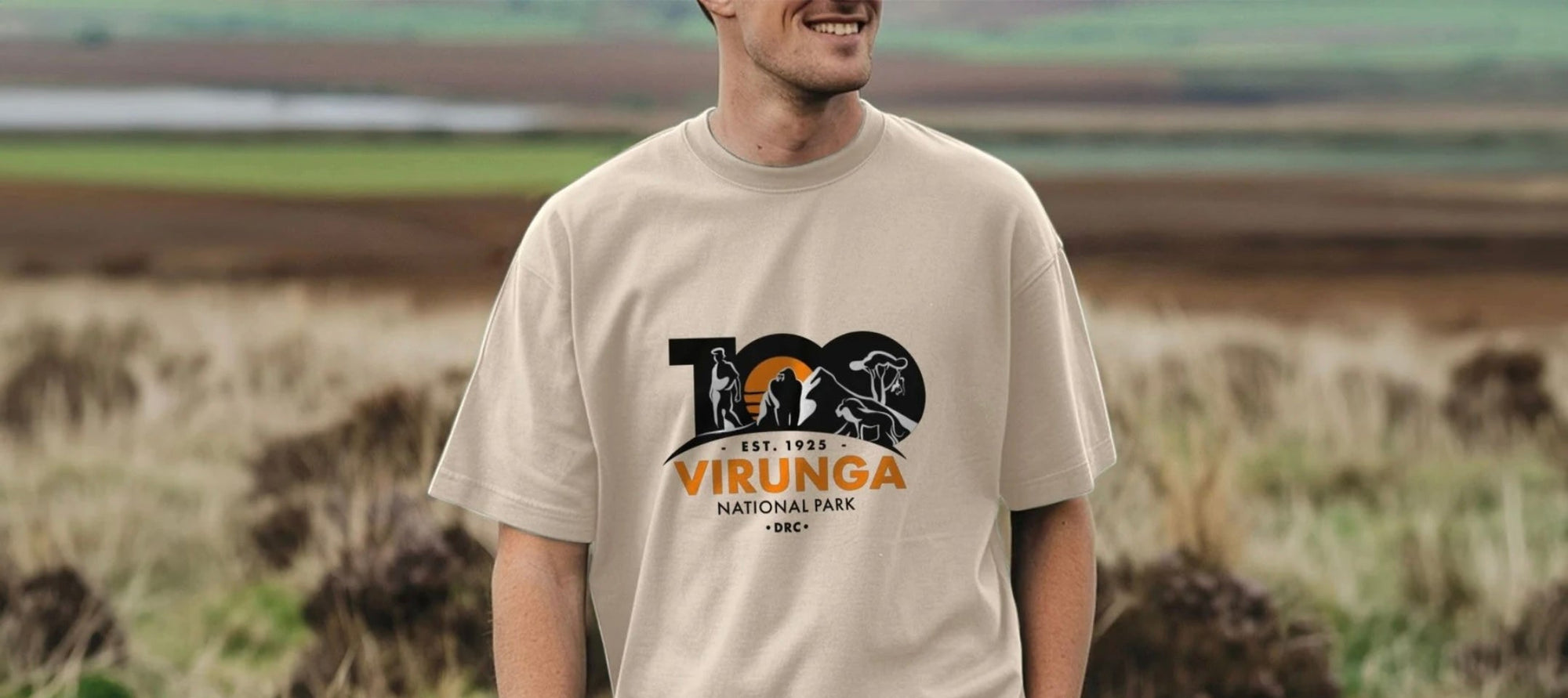 Person wearing a beige t-shirt with Virunga National Park logo in a field