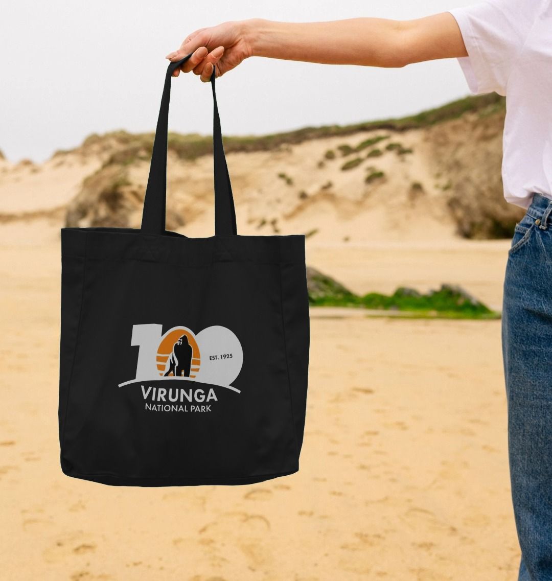 A person holding a black limited edition Virunga shopper bag 